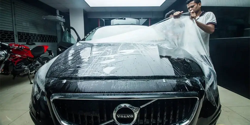 Paint Protection Film (PPF) Coating being installed on a black-coloured luxury car