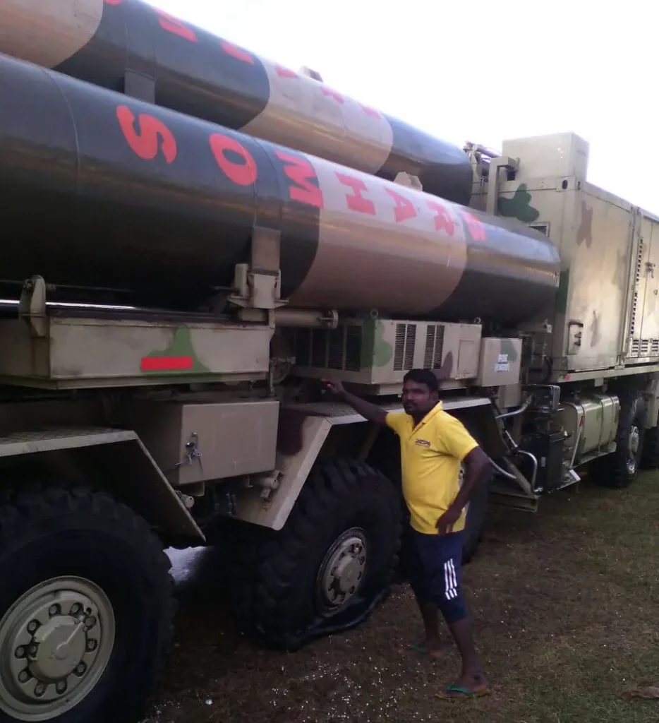 A BrahMos supersonic cruise missile in camouflage paint placed atop a carrier truck