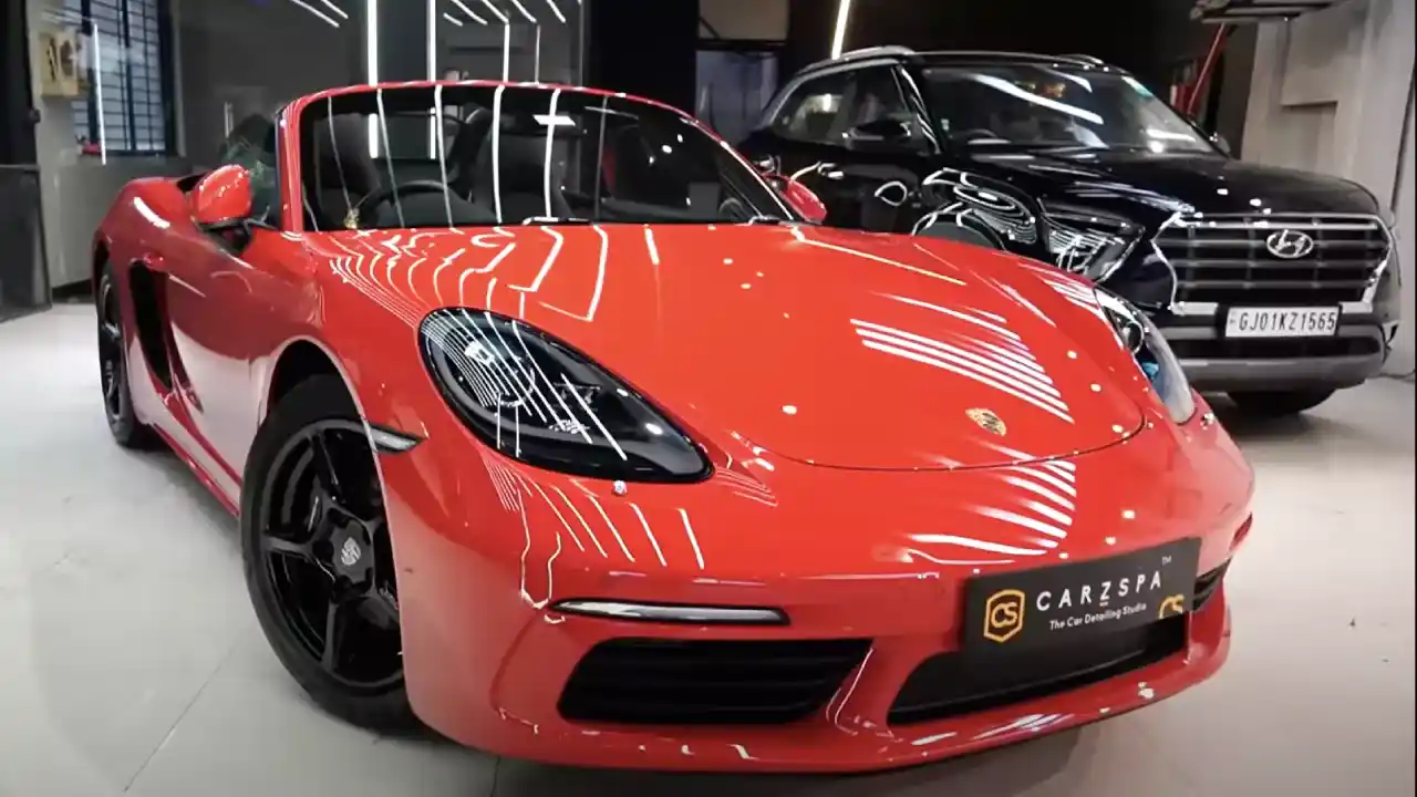 A red sports car parked inside the studio of a car detailing franchise