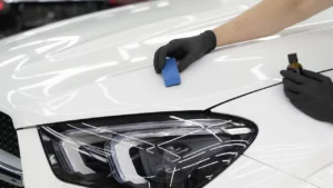 Image of a white car being ceramic coated in a detailing studio
