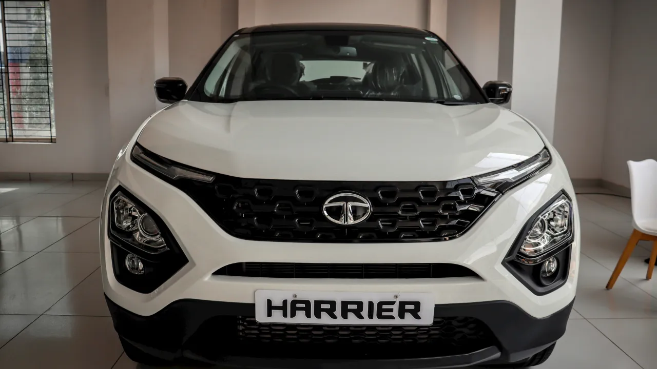 The front view of a white Toyota Harrier SUV inside a showroom