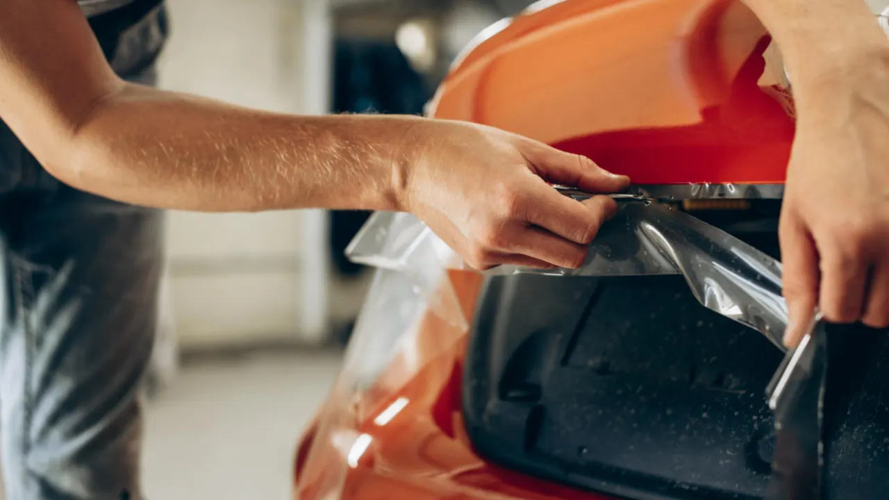 a paint protection film being installed on a red car