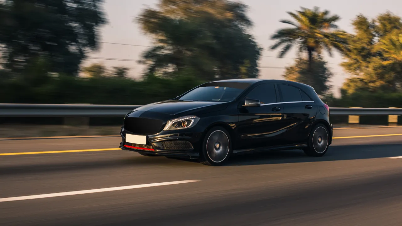 A black, shiny SUV driving on the highway