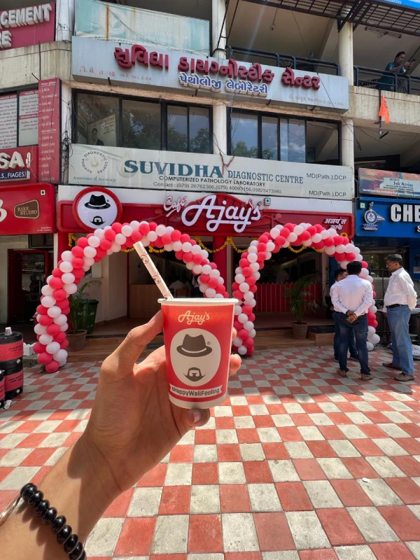 a cafe entrance with a coffee cup being held in front of it