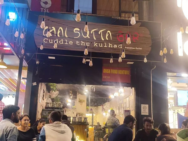 a mini Indian cafe store front with a brown wooden banner