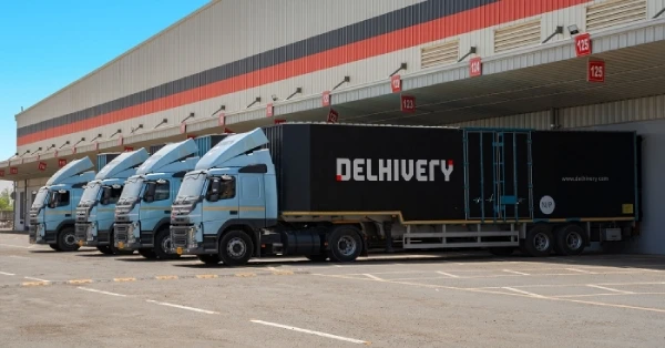 A warehouse with many delivery trucks lined up outside