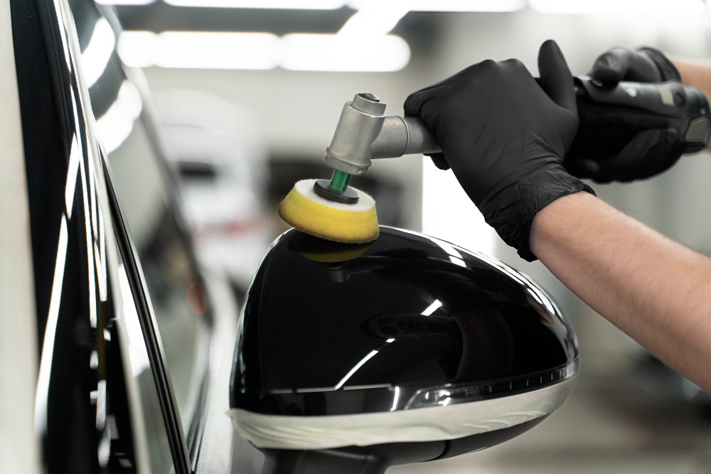 Close-up image of the left rear-view mirror body being polished using a small polisher machine