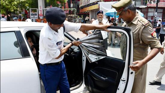 Traffic policemen remove window tint film from a car in India Caption: Source - Hindustan Times & ANI