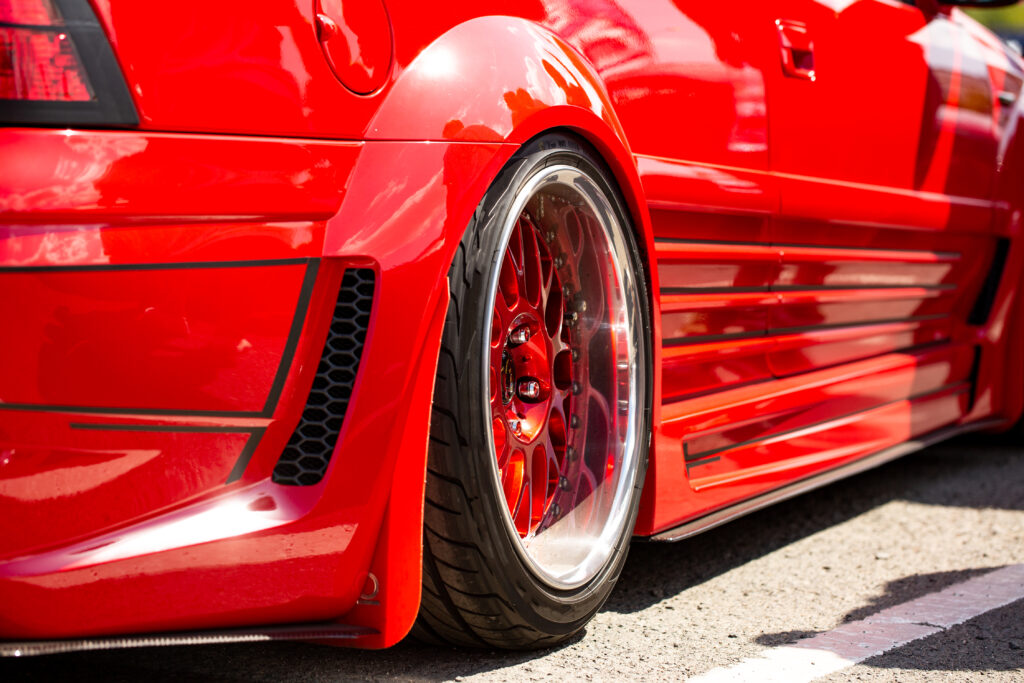 Rear-view of the wheel of a red coloured modified car