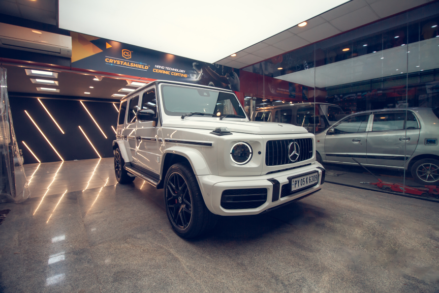 A white Mercedes G Wagon stands parked inside a CarzSpa Detailing Studio