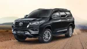 A black Toyota Fortuner parked on a dusty road