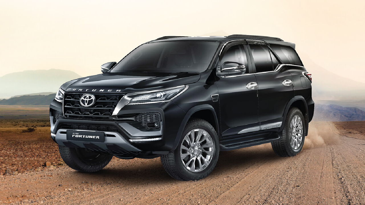 A black Toyota Fortuner parked on a dusty road