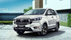 A grey Toyota Innova Crysta parked outside a house