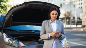 Businesswoman using a smartphone to get help for her broken-down car