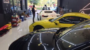 Luxury cars like Ferraris and Lamborghinis stay parked inside a car detailing workshop in Hyderabad