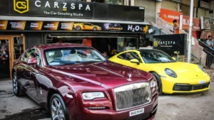 Two luxury cars parked outside a CarzSpa Detailing Studio in Gujarat