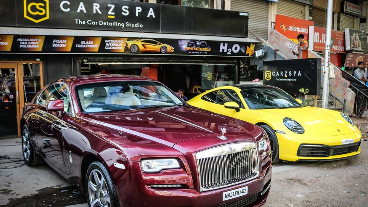 Two luxury cars parked outside a CarzSpa Detailing Studio in Gujarat