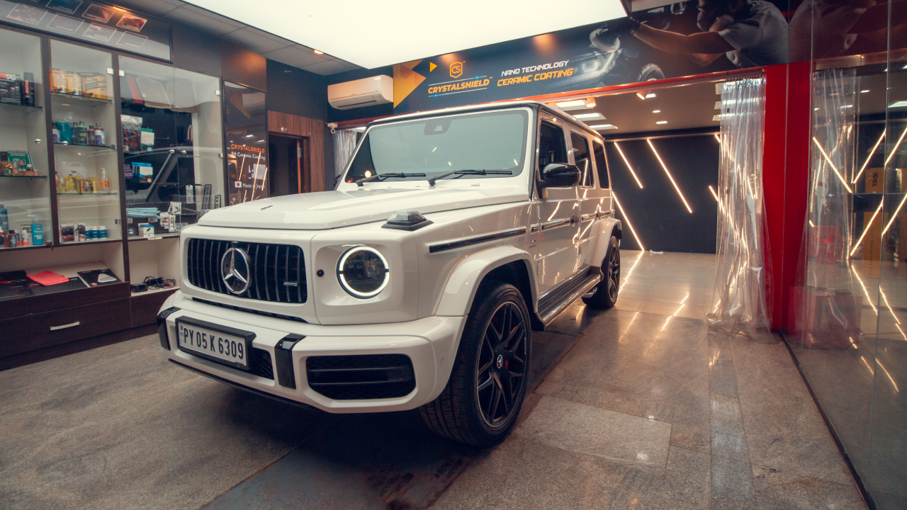 A white Mercedes G-Wagon parked inside a CarzSpa Detailing studio