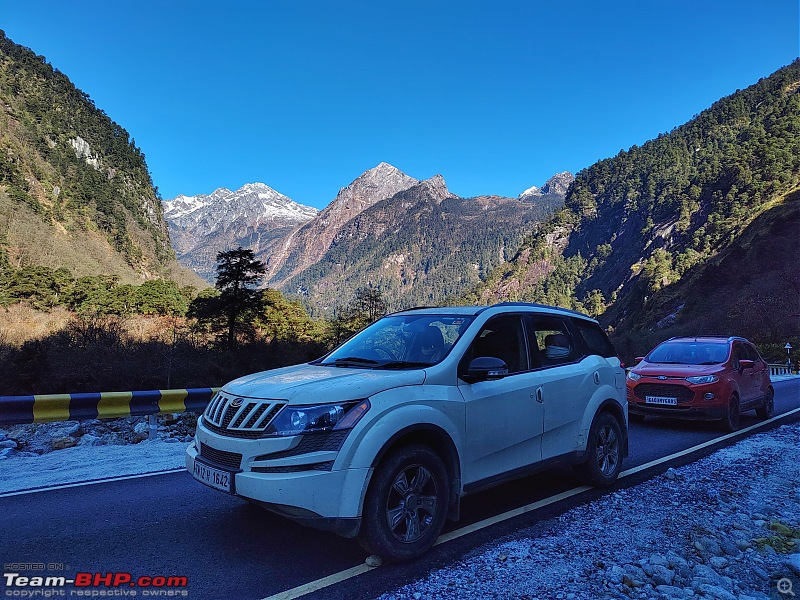 Cars driving with mountains in the backdrop on the Bruni stretch in North East India