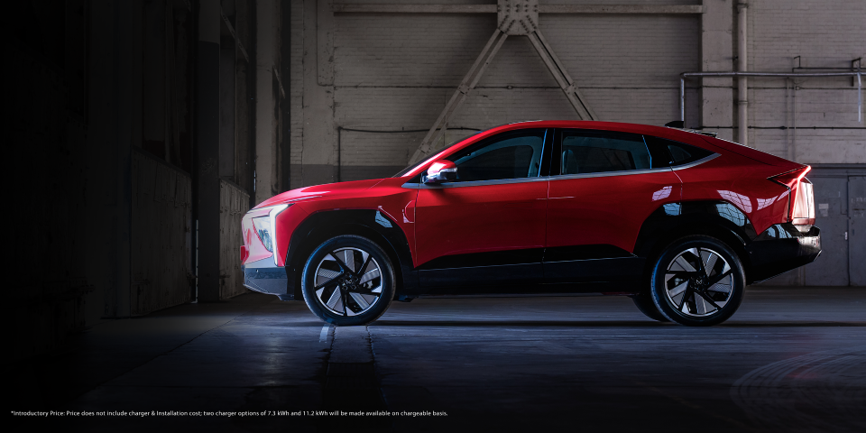 A red Mahindra XEV 9e parked inside a store room