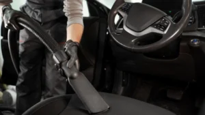 A professionally cleaned car interior showing a spotless dashboard, shiny gear console, and conditioned leather seats.