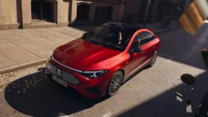 A futuristic, red Mercedes-Benz CLA Electric showing its illuminated star-pattern grille and sleek coupe silhouette on a street.