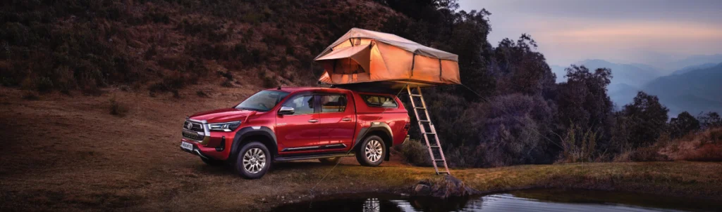 A red Toyota Hilux with a text canopy on its back