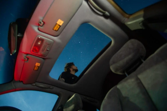 view of sky from moonroof of a car at night