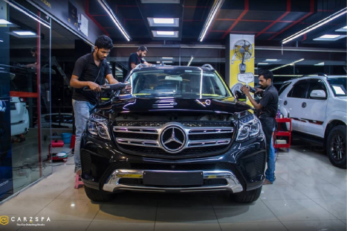 A car detailing franchise studio team working on a vehicle