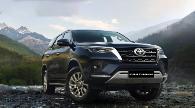 A black Toyota Fortuner parked on a rocky hillock