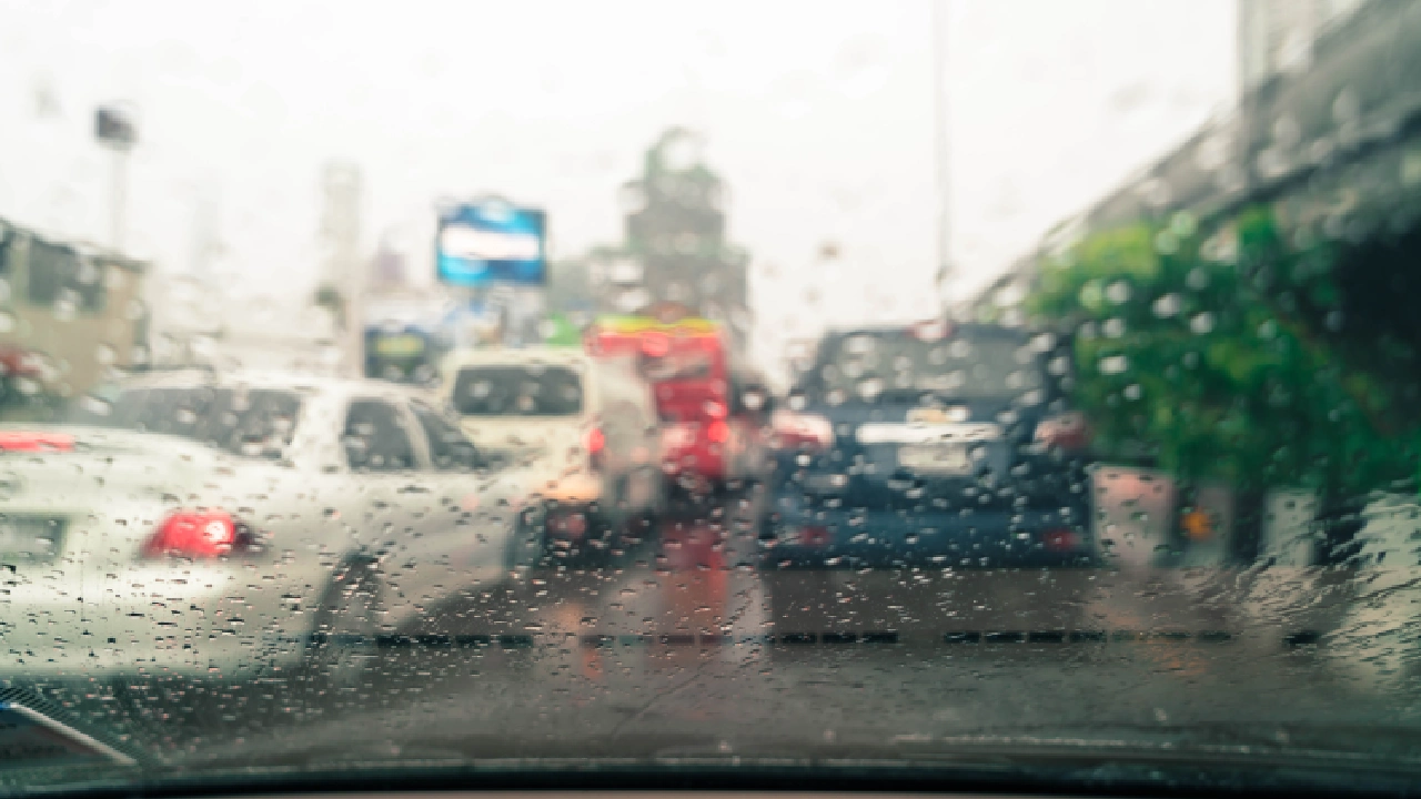raindrops on a car windshield while driving in the monsoon