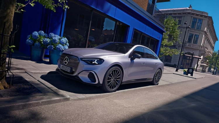 Silver Mercedes-Benz E-Class parked outside near a sidewalk