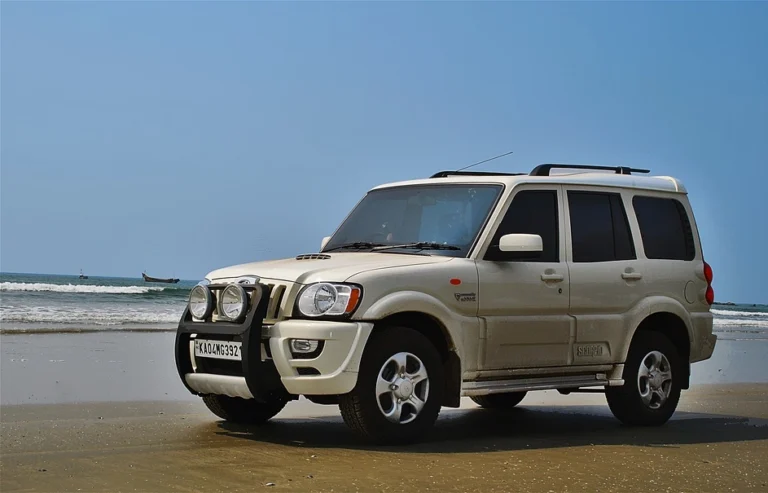 A white Mahindra Scorpio parked on the beach side