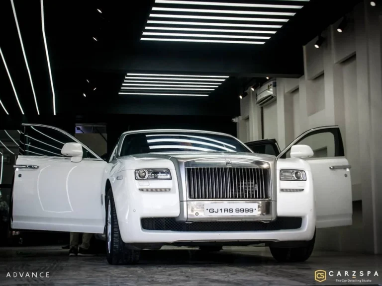 A white coloured Rolls Royce parked outside a detailing garage