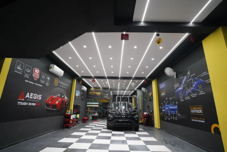 A car detailing studio with a black coloured car inside it