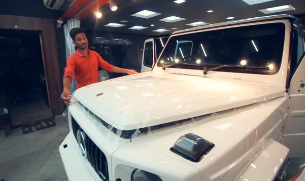 A clear PPF being applied on the bonnet of a white Mercedes G-Wagon