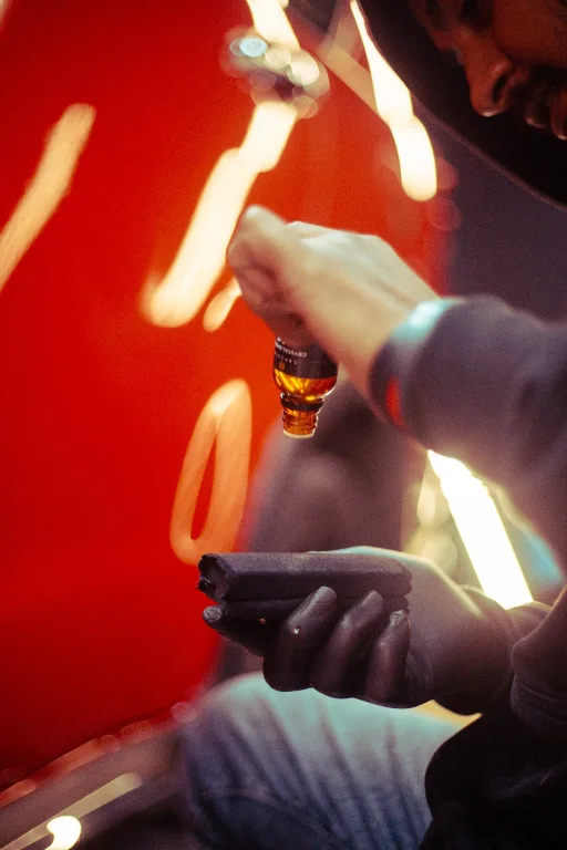 Detailer applying ceramic coating onto the bonnet of a red car using a suede applicator block.