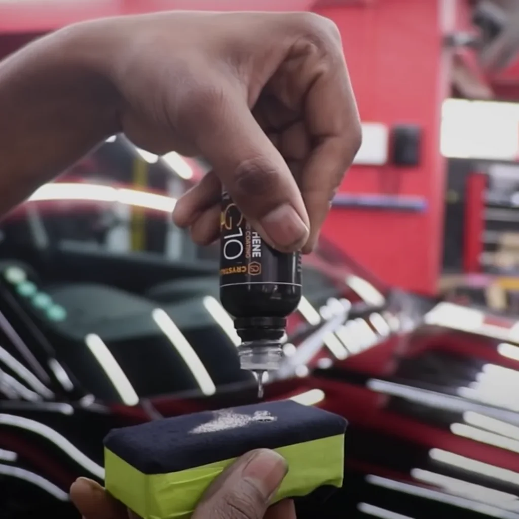A worker drops graphene ceramic coating on an applicator