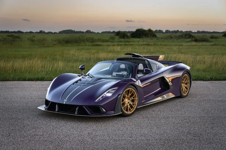 A purple Hennessey Venom F5 parked aside on a racetrack