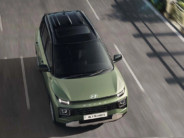Top shot of an olive green Exter driving down a road