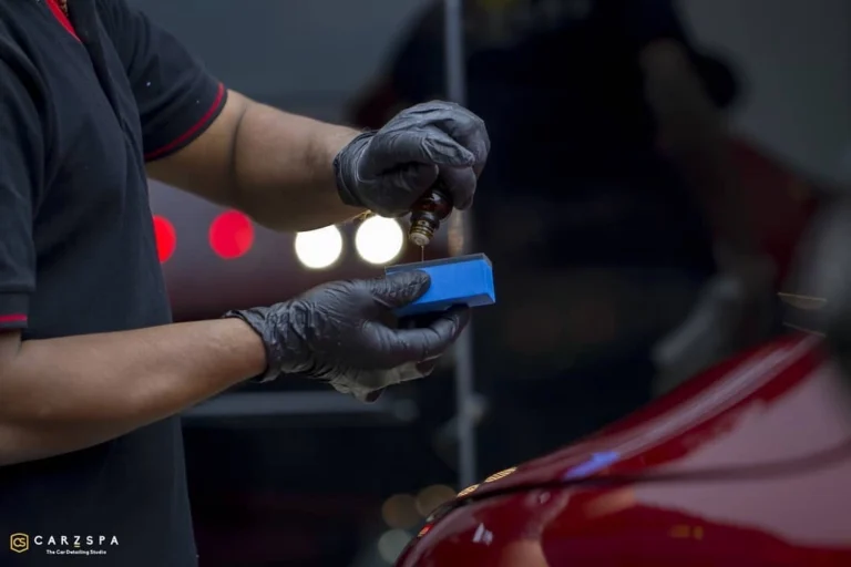 A worker drops ceramic coating on an applicator
