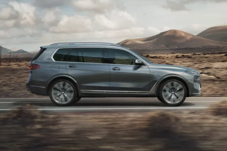 A BMW X7 parked in a slightly shaded area