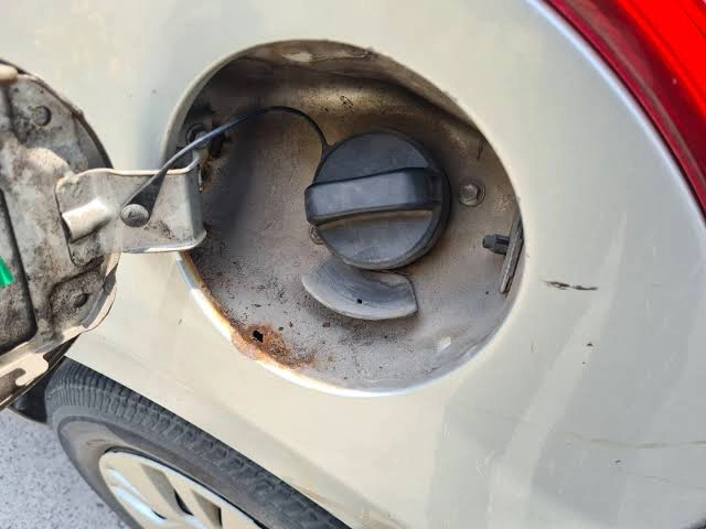 ust on the side of fuel tank slot of a white car