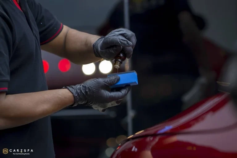 A worker drops ceramic coating liquid on an applicator