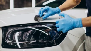 Close-up of a professional detailing technician applying ceramic coating to a car's paintwork