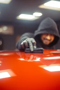 Close-up shot of a worker applying ceramic coating on a car